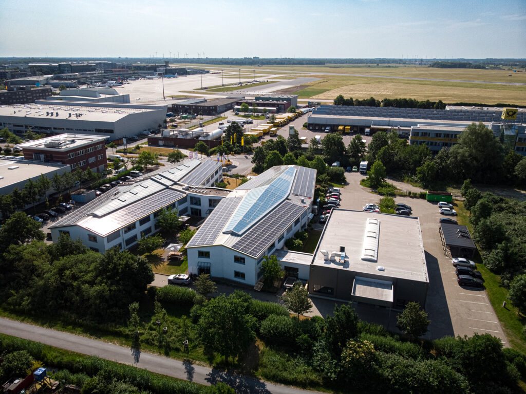 Aerial view of the AES company buildings in Bremen with the large photovoltaic (PV) system installed on the roof, located near the airport.